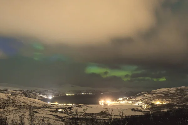 Aurores boréales au-dessus des arbres dans un paysage hivernal . — Photo