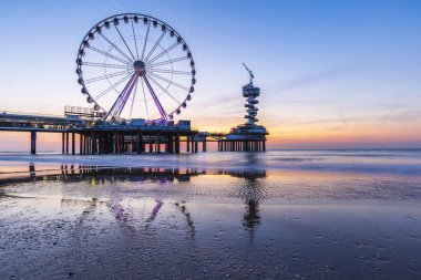 Renkli mavi saat günbatımı sahil şeridi, plaj, iskele ve ferris w üzerinde