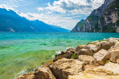 Güzel bir yaz gününde İtalya 'nın Garda Gölü' ndeki doğa manzarası. Mavi su, kayalar, dağlar, güneş ışığı ve berrak gökyüzü.