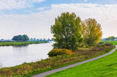 Van Cuijk arazisi, Cuijk köyünün tarım arazisi ve Hollanda 'nın Meuse nehri, mavi gökyüzünün altında. Seyahat için popüler turistik dönüm noktası