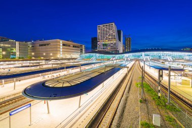 Alacakaranlıkta Utrecht merkez tren istasyonu. Modern çağdaş mimari ve Hollanda 'nın en büyük ve en önemli demiryolu taşıma merkezi.