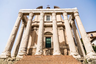 Mavi gökyüzü ile güneşli bir günde antoninus ve faustina Tapınağı yeşil kapıya dış görünümünü kapat