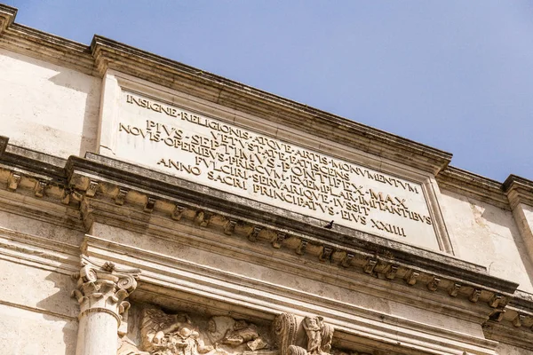 Inscription on the Arch of Titus in the Roman Forum on a sunny day with blue skies