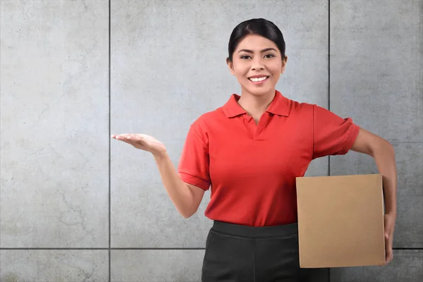 Sonriente Asiático Entrega Mujer Con Paquete Gris Pared Fondo — Foto de Stock