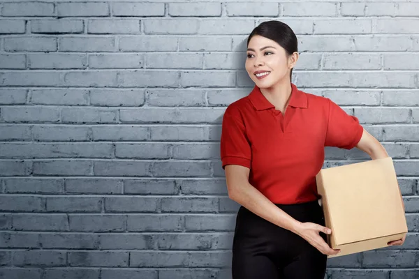 Glimlachend Aziatische Levering Vrouw Met Het Pakketje Met Muur Achtergrond — Stockfoto