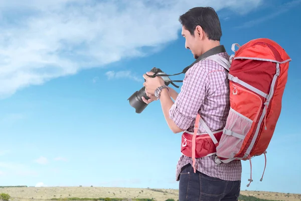 英俊的亚洲游客与背包手持相机与蓝天背景 — 图库照片