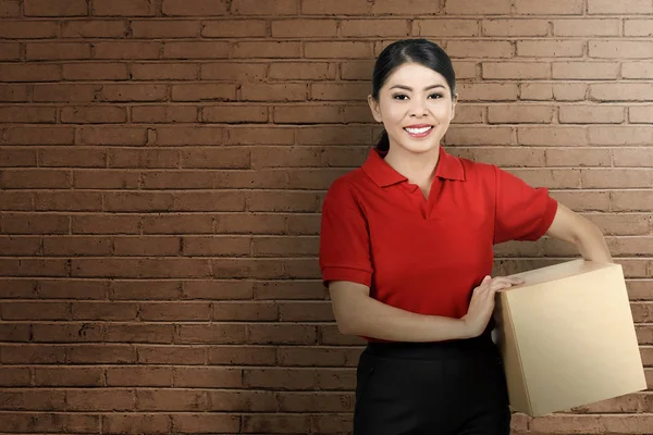 Consideravelmente Ásia Courier Mulher Segurando Pacote Parede Fundo — Fotografia de Stock
