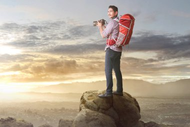 Kamera ve sırt çantası dağda bir fotoğraf çekmeye hazır hale ile mutlu Asya Turizm