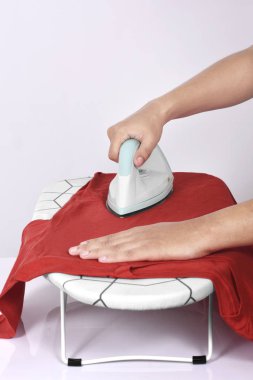 Ütü masası beyaz arka plan üzerinde izole renkli elbise Ütü insanlar