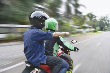 Arkadan Görünüş motosiklet taksi şoförü giderken sokakta yönetmenlik-yolcu