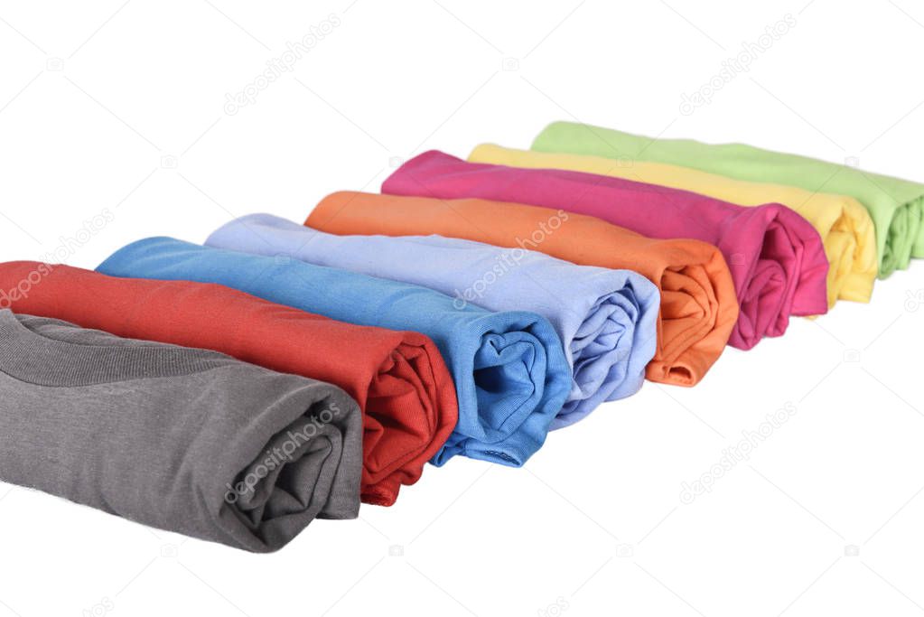 Row of rolled t-shirts with multi colored isolated over white background