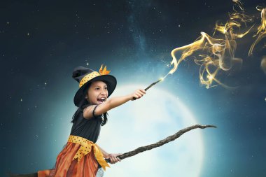 Sihirli değnek ile gece arka plan kullanan güzel Asya cadı kız