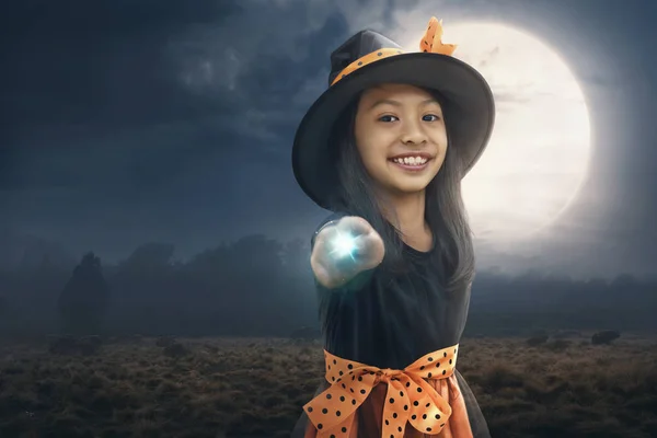 微笑亚洲儿童女孩使用她的魔力与月光背景 — 图库照片