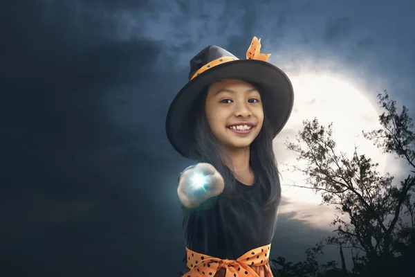愉快的亚洲巫婆女孩用魔杖在夜 — 图库照片