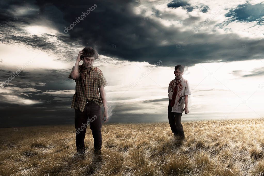 Spooky zombies on the grassland with dramatic sky background. Halloween concept