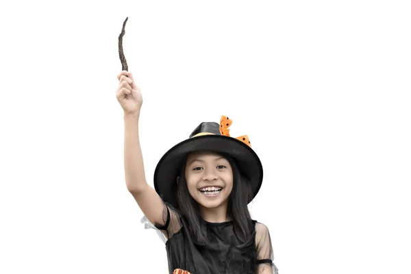 愉快的亚洲小女孩在巫婆服装拿着一根魔杖隔绝在白色背景上 — 图库照片