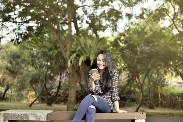 Sonriendo Chica Asiática Con Teléfono Móvil Sentado Banco Del Parque — Foto de Stock