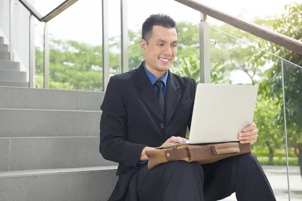 Close up view of asian businessman with laptop outside office room