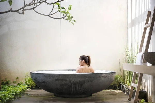 亚洲妇女在水疗沙龙浴缸中放松的后景色 — 图库照片