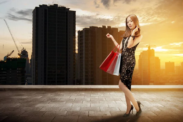 都市の通りに買い物袋を保持している陽気なアジア高級女性 黒い金曜日のコンセプト — ストック写真