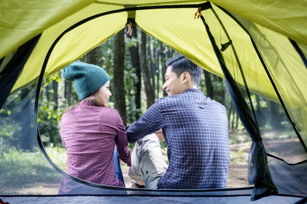 在帐篷外放松的亚洲情侣的后方视图 从内部查看 — 图库照片