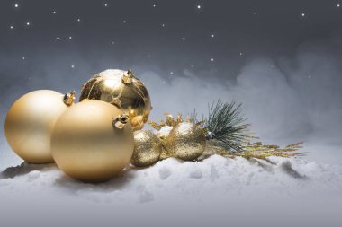 Kar üzerinde parlak altın Noel topları. Noel süs