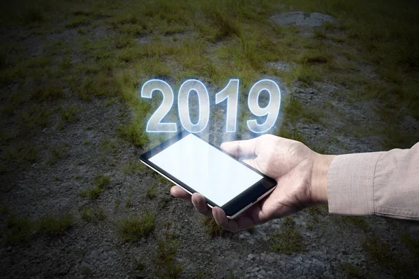 Hand holding phone with 2019 number showing from screen. Happy New Year 2019