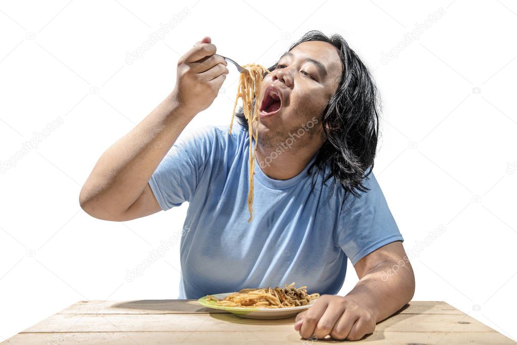 Portrait of asian fat man eating fast food spaghetti isolated over white background. Fat man diet concept