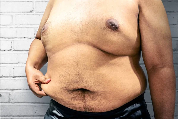 Fat man with his big belly over white wall background. Fat man diet concept