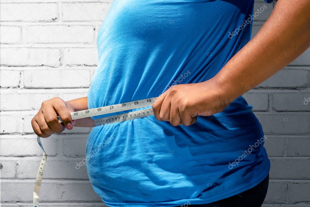 Fat man using measuring tape to measuring his belly at home. Fat man diet concept