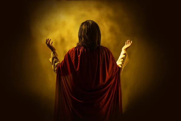 Sarı parlak arka plan ile Tanrı'ya dua İsa'nın arkadan görünüş