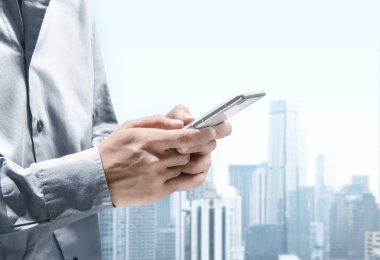 Şehrin üzerinde ileti için cep telefonu kullanarak iş adamı 