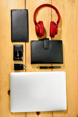 üstten görünüm çeşitli iş nesnelerinin. dizüstü bilgisayar, kamera, cüzdan, defter ve kulaklıklar için ahşap masa üzerinde çalışıyorum. Yukarıdan görüntülemek