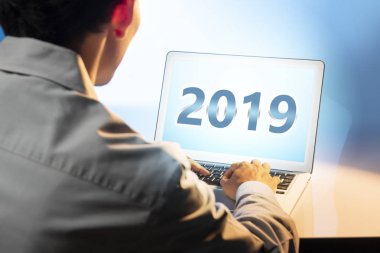 Ekran üzerindeki 2019 numarasıyla dizüstü kullanarak iş adamı. Mutlu yeni yıl 2019