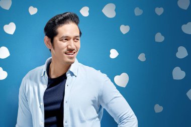 Mutlu Sevgililer arka plan üzerinde duran mavi rahat kıyafetler Asya adam. Sevgililer günü