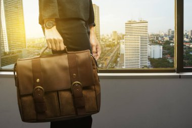 Evrak çantası ile şehir ofis pencere yanında arka plan üzerinde yürüme ile iş kadını
