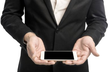 Cep telefonu elindeki beyaz arka plan üzerinde izole ayakta tutan bir iş adamı. Alan boşaltmak için siyah ekran