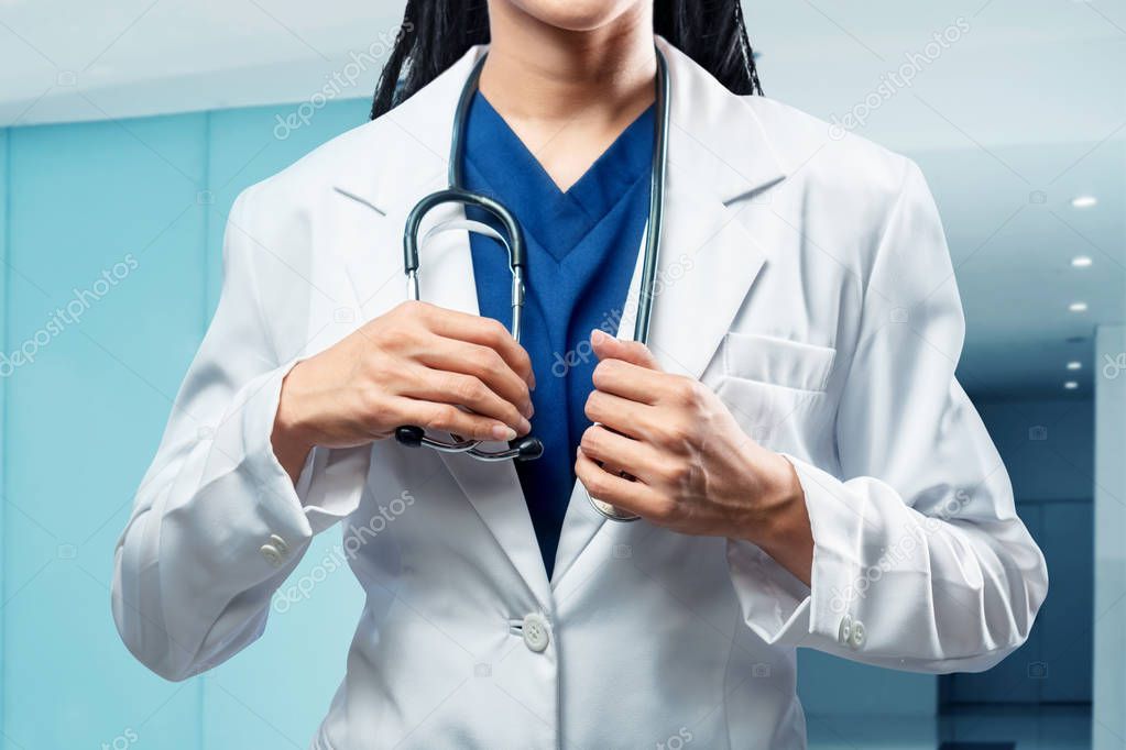 Female doctor in medical gown with stethoscope on her neck