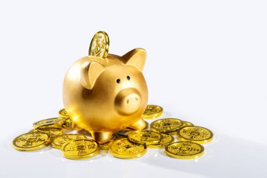 golden piggy bank with pile of coins on white background 