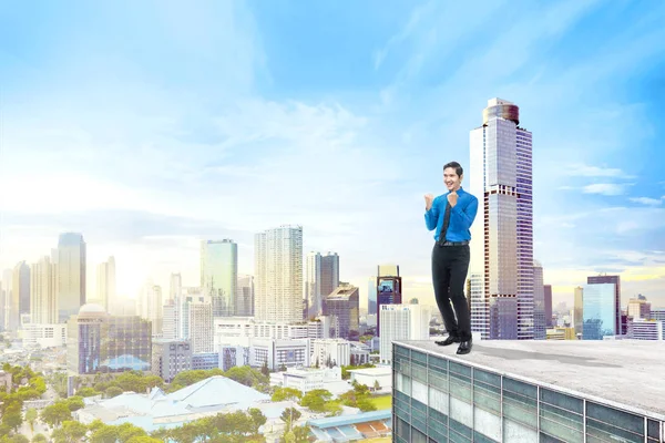 都市景観の背景の建物の屋上の上に立って幸せなアジア系のビジネスマン — ストック写真