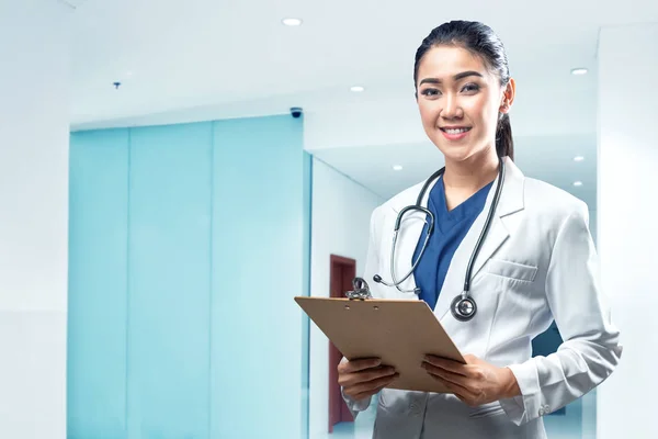 漂亮的亚洲女医生穿着白色外套听诊器和剪贴板在医院 — 图库照片