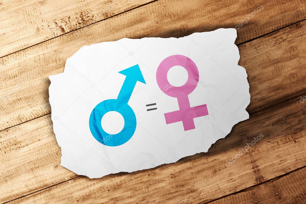 Symbol of male gender is equal to female in white paper on wooden table. Equality gender concept