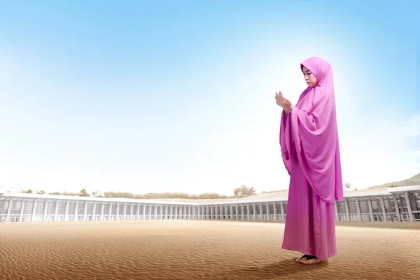 かなりアジアの女性のピンクのベールを踏んで砂漠で 手を上げるし モスクの外見て — ストック写真