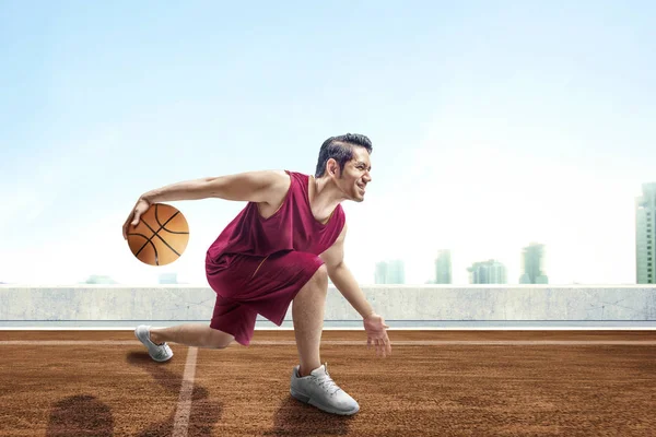 Ung Asiatisk Man Basketspelare Poserar Dribblingar Bollen Mellan Benen Utomhus — Stockfoto