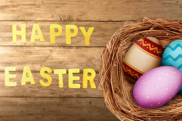 Huevos Coloridos Pascua Nido Mesa Madera Con Feliz Saludo Pascua — Foto de Stock