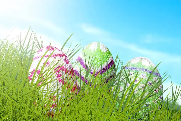 Colorful easter eggs hidden on the green grass with blue sky background. Happy Easter