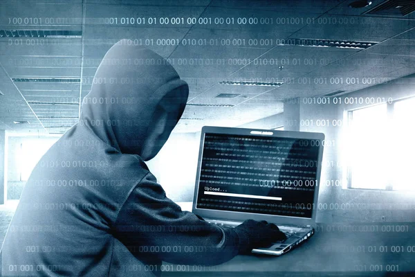 Hacker dalam hoodie hitam menggunakan laptop di meja untuk hacking syste — Stok Foto