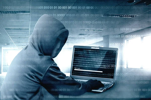 Hacker i svart hoodie med laptop på skrivbordet till hacking Systema — Stockfoto