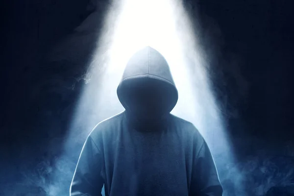 Hacker in zwarte hoodie staande met rook en licht van de te — Stockfoto