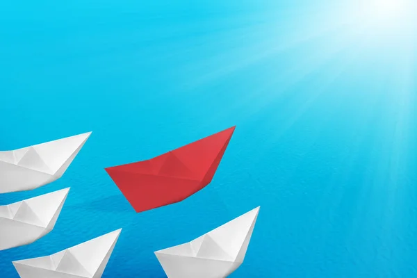 Red paper boats lead the white paper boats on the sea